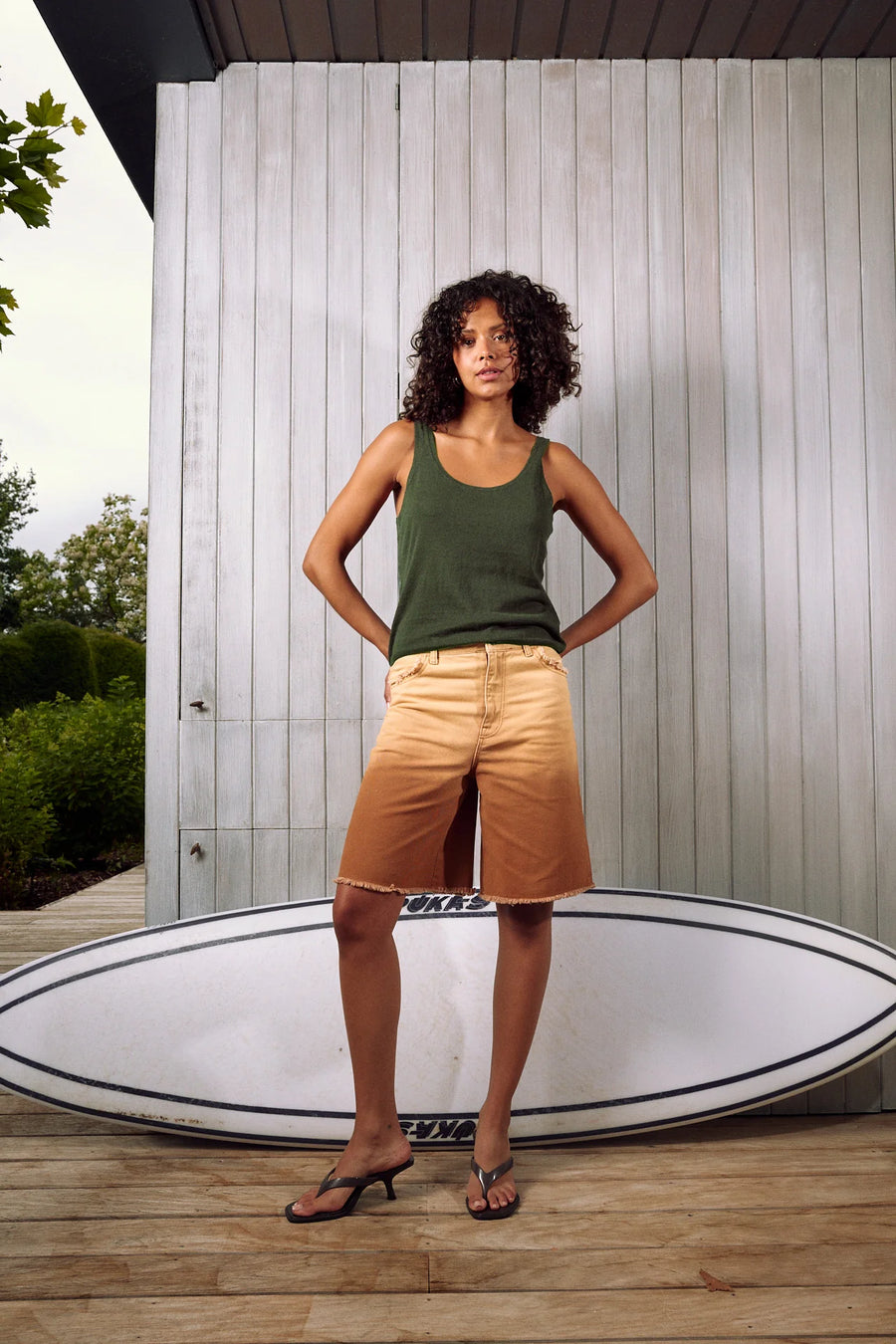 Woman wearing a dark green knit tank top