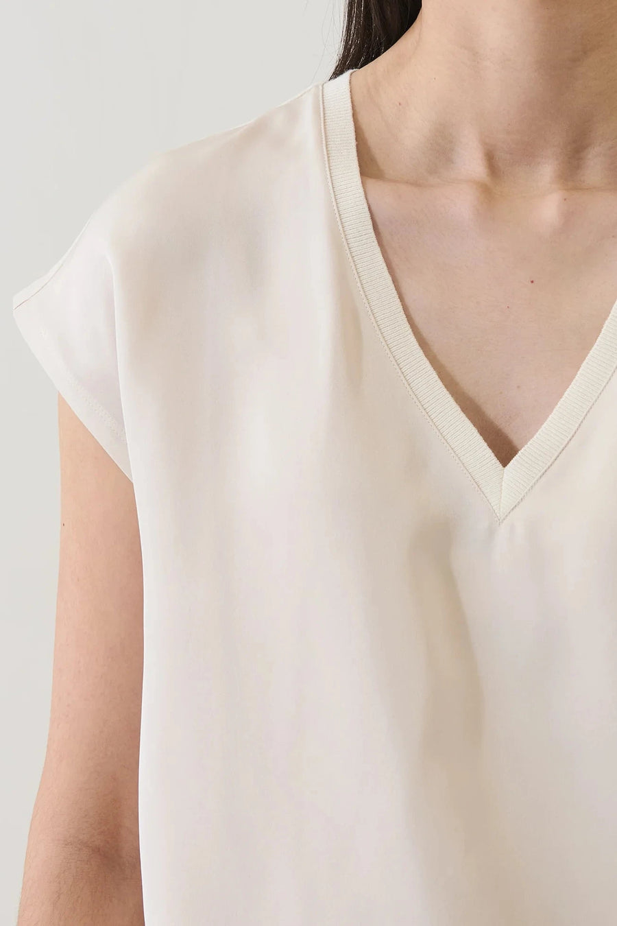 Close up of Woman wearing an off white v neck tee shirt