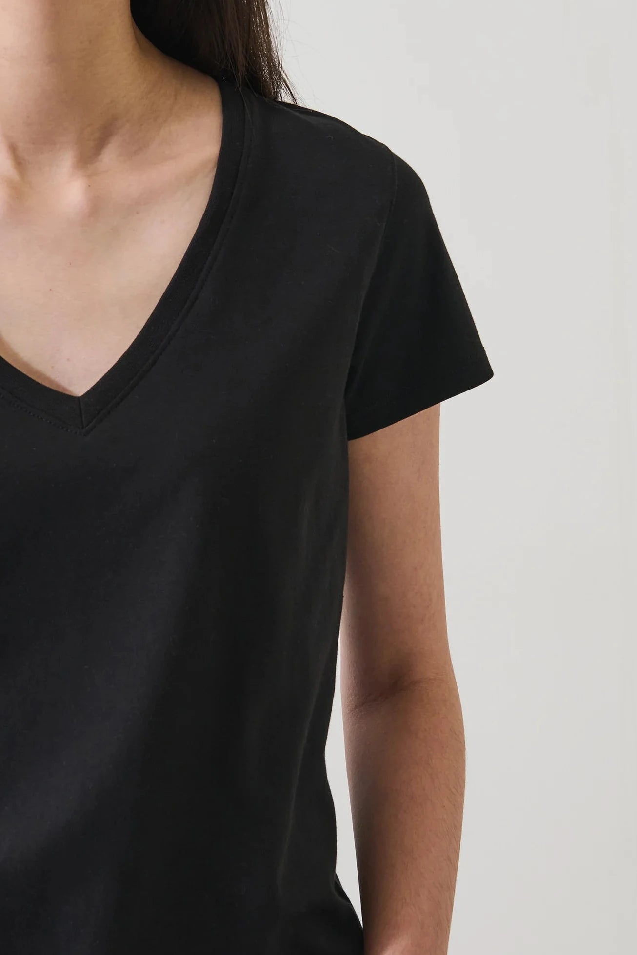 Close up of a woman wearing a black v neck tee
