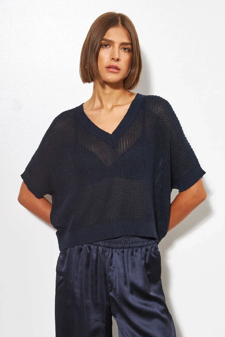 Woman wearing a dark ocean blue knit top 