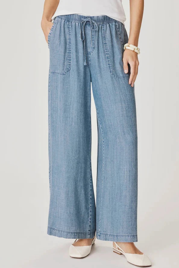 Woman wearing a pair of indigo flowy pants With drawstring waistband