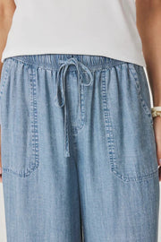 Close up of Woman wearing a pair of indigo flowy pants With drawstring waistband
