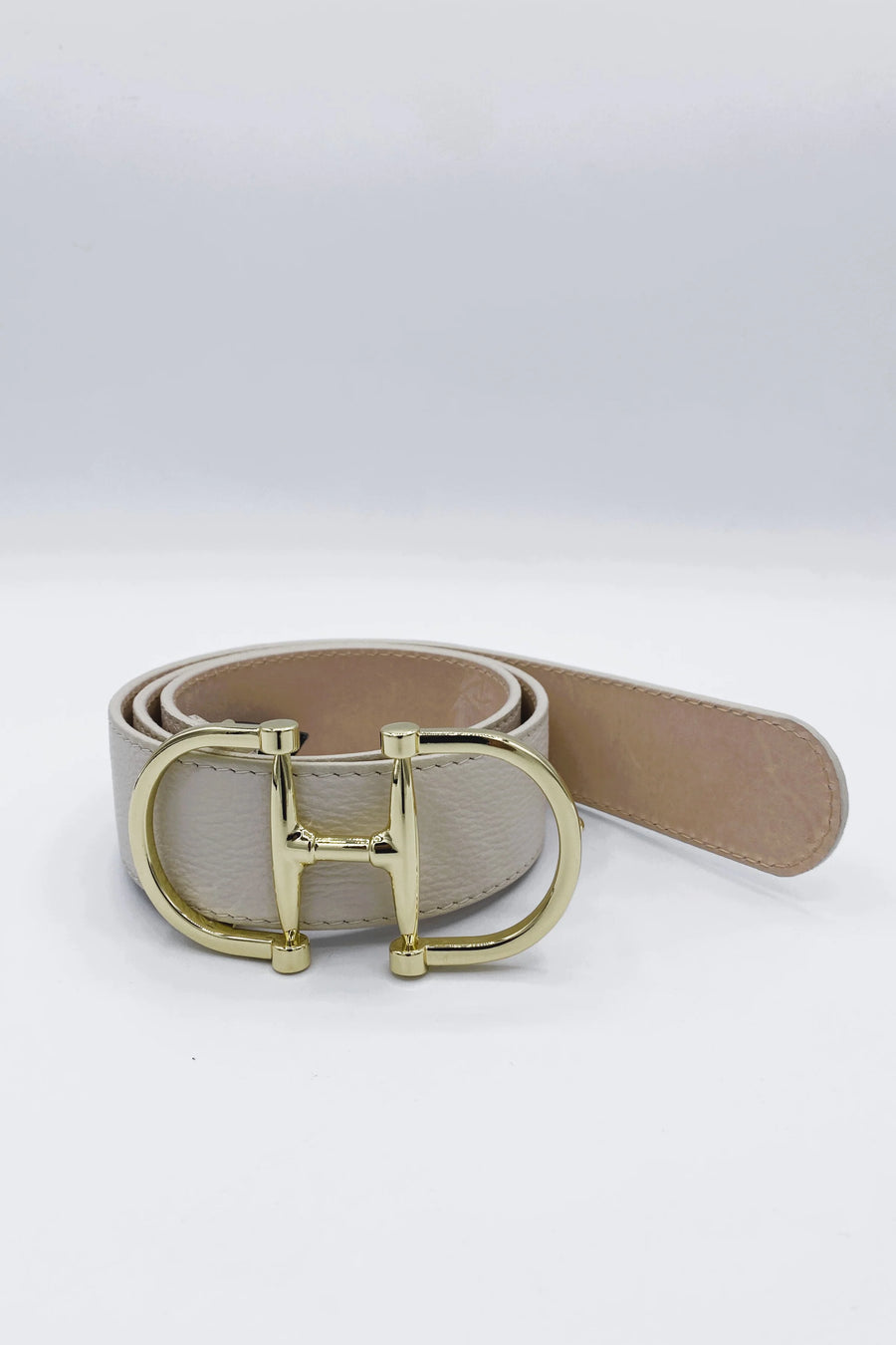 Belt with a gold “h” belt buckle and a marble colored leather belt strap