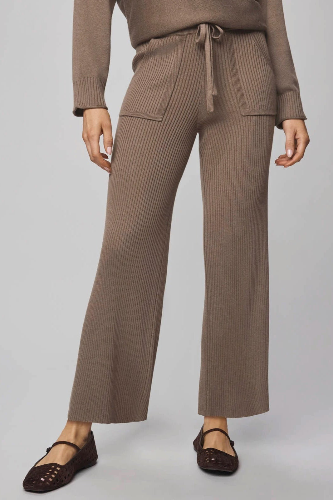 Brown ribbed knit pants worn by a person on a light gray background