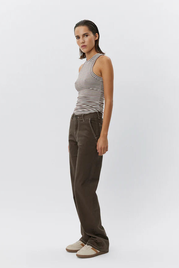 Woman wearing a brown and white striped sleeveless tank top with a fitted silhouette, side
