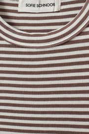 Woman wearing a brown and white striped sleeveless tank top with a fitted silhouette, fabric detail