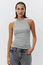 Woman wearing a grey and white striped sleeveless tank top with a fitted silhouette, front