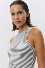Woman wearing a grey and white striped sleeveless tank top with a fitted silhouette, front