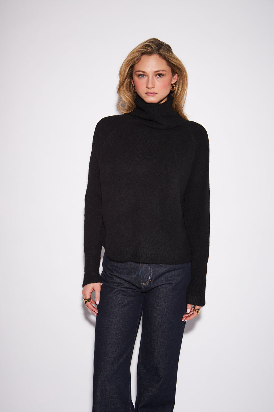 model wearing a charcol grey knit turtleneck sweater with a relaxed fit and long sleeves 
