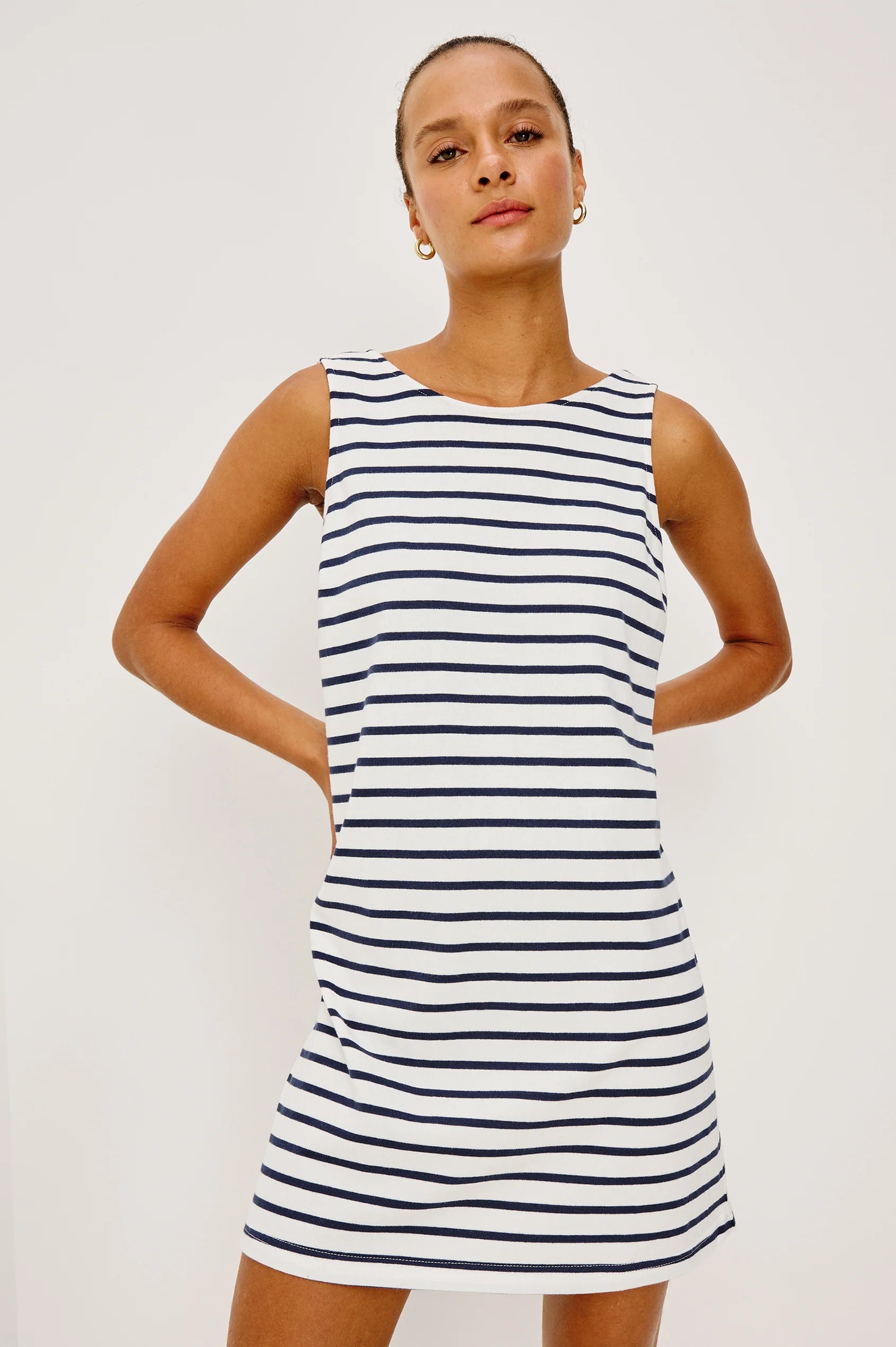 Woman wearing a navy and white striped dress with a boat neck 