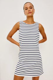 Woman wearing a navy and white striped dress with a boat neck 