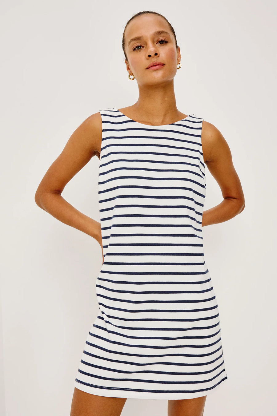 Woman wearing a navy and white striped dress with a boat neck 