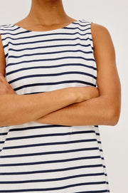 Woman wearing a navy and white striped dress with a boat neck 