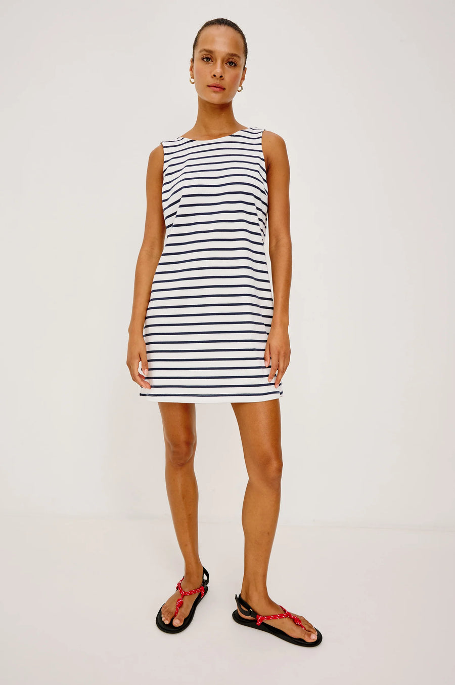 Woman wearing a navy and white striped dress with a boat neck 