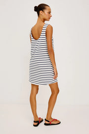 Woman wearing a navy and white striped dress with a boat neck 