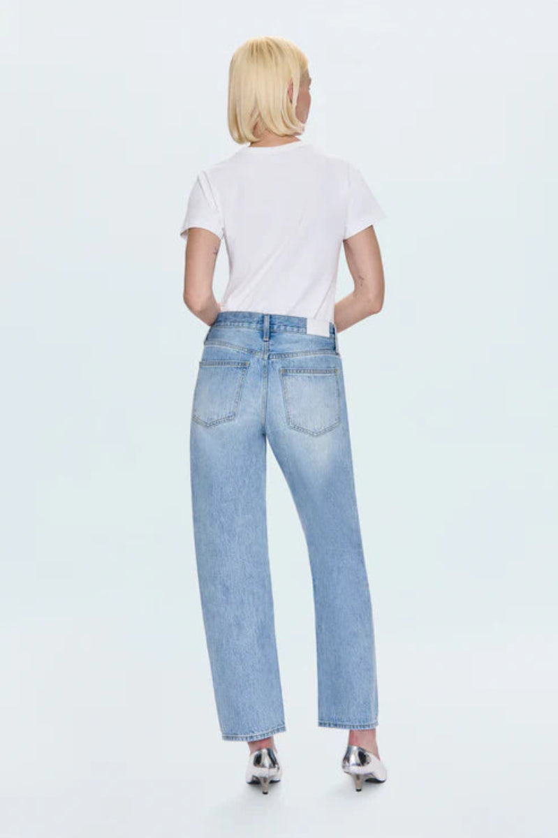 Person wearing light blue jeans and a white shirt on a white background