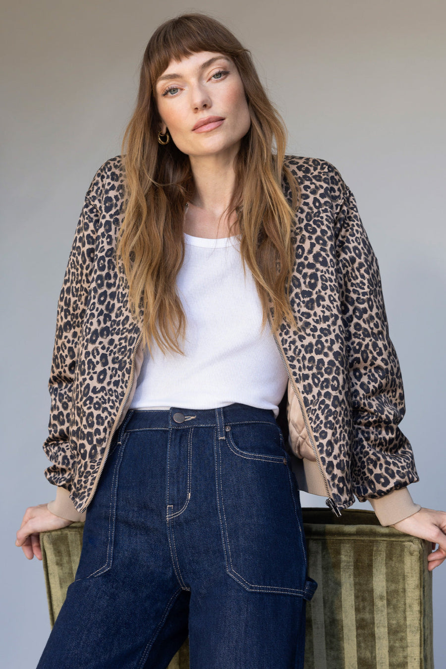 Front view of woman wearing an unzipped up leopard print bomber jacket
