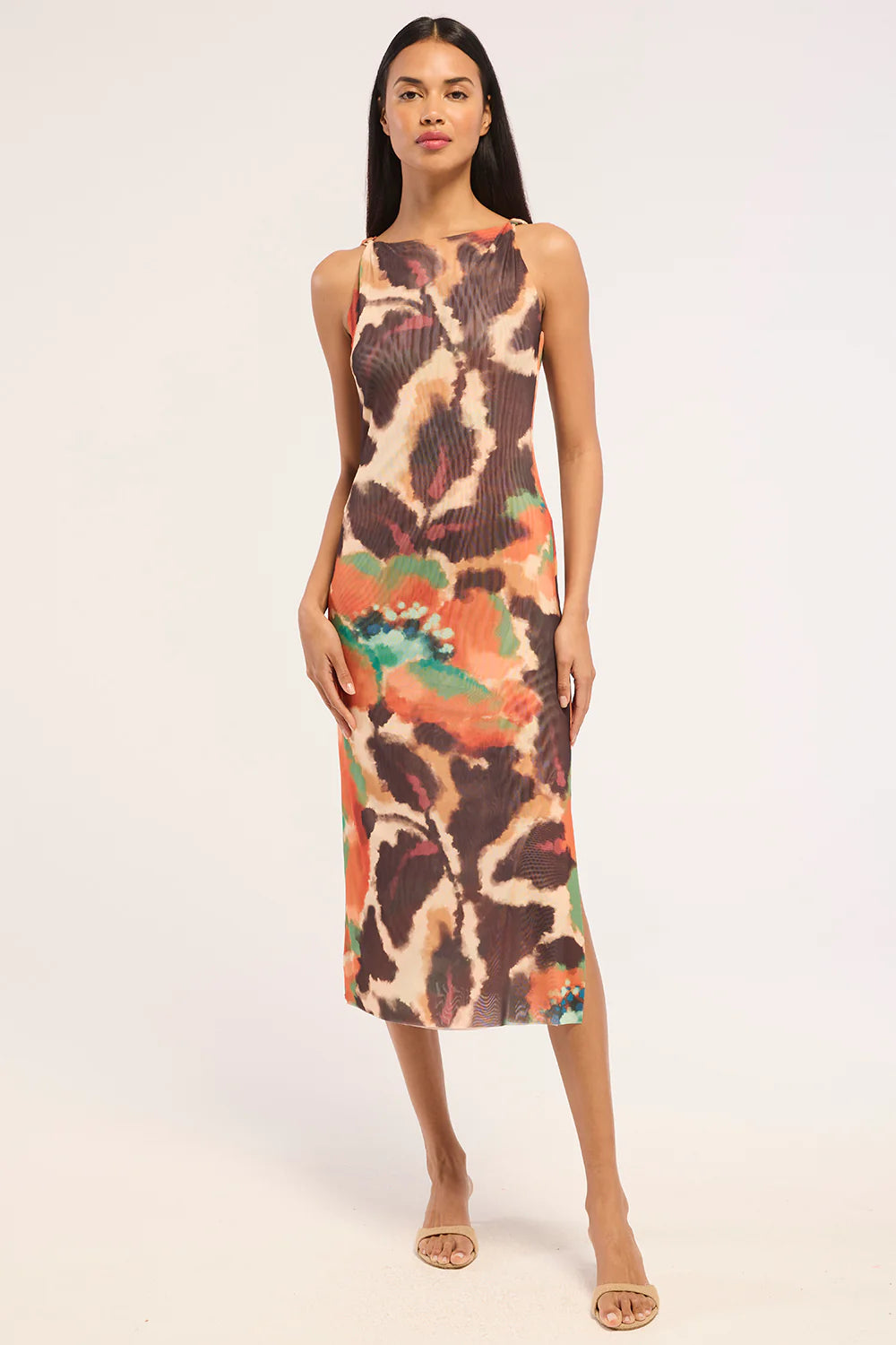 Woman wearing a patterned mesh dress with slit. 