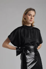 Front view of a woman wearing a high neck satin loose fitting blouse 
