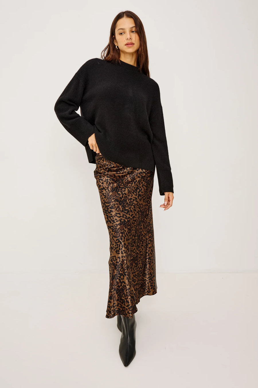 woman wearing a black cashmere blend sweater and a leopard dress underneath 