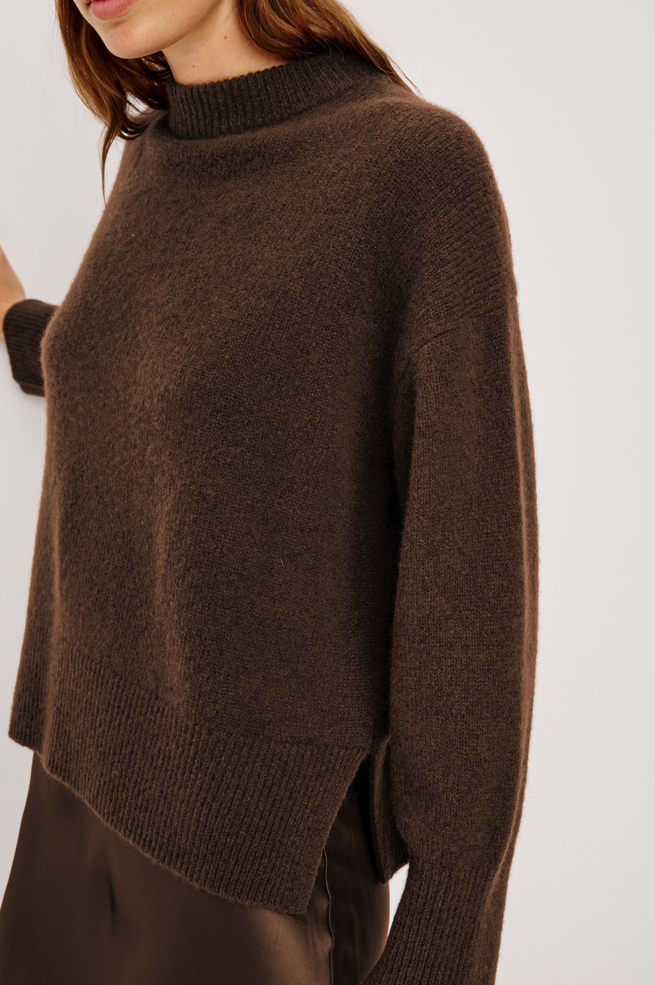 Close up view of woman wearing an oversized cashmere brown sweater