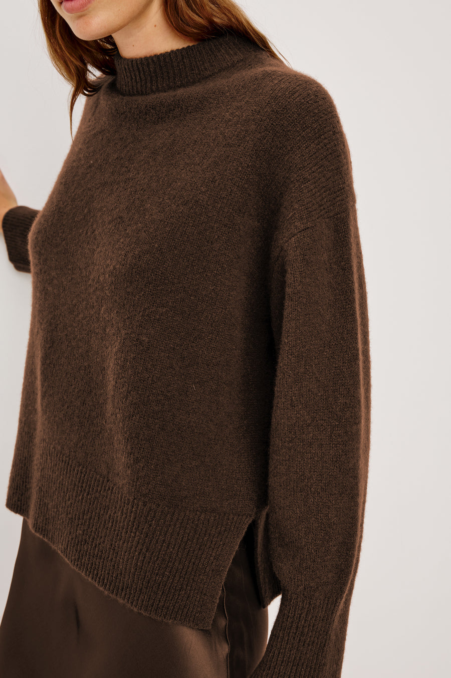 Close up view of woman wearing an oversized cashmere brown sweater