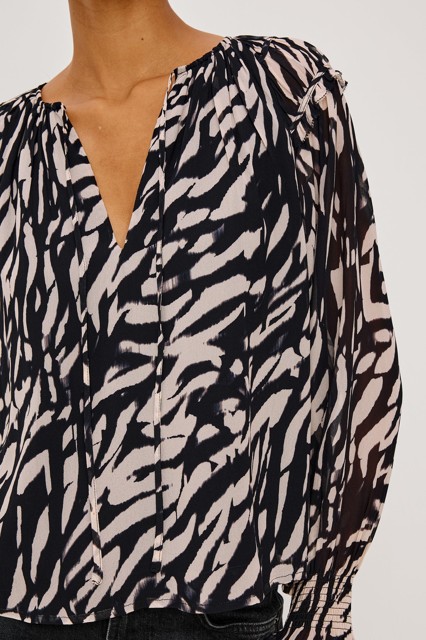close-up of a woman wearing a tiger stripped patterned blouse
