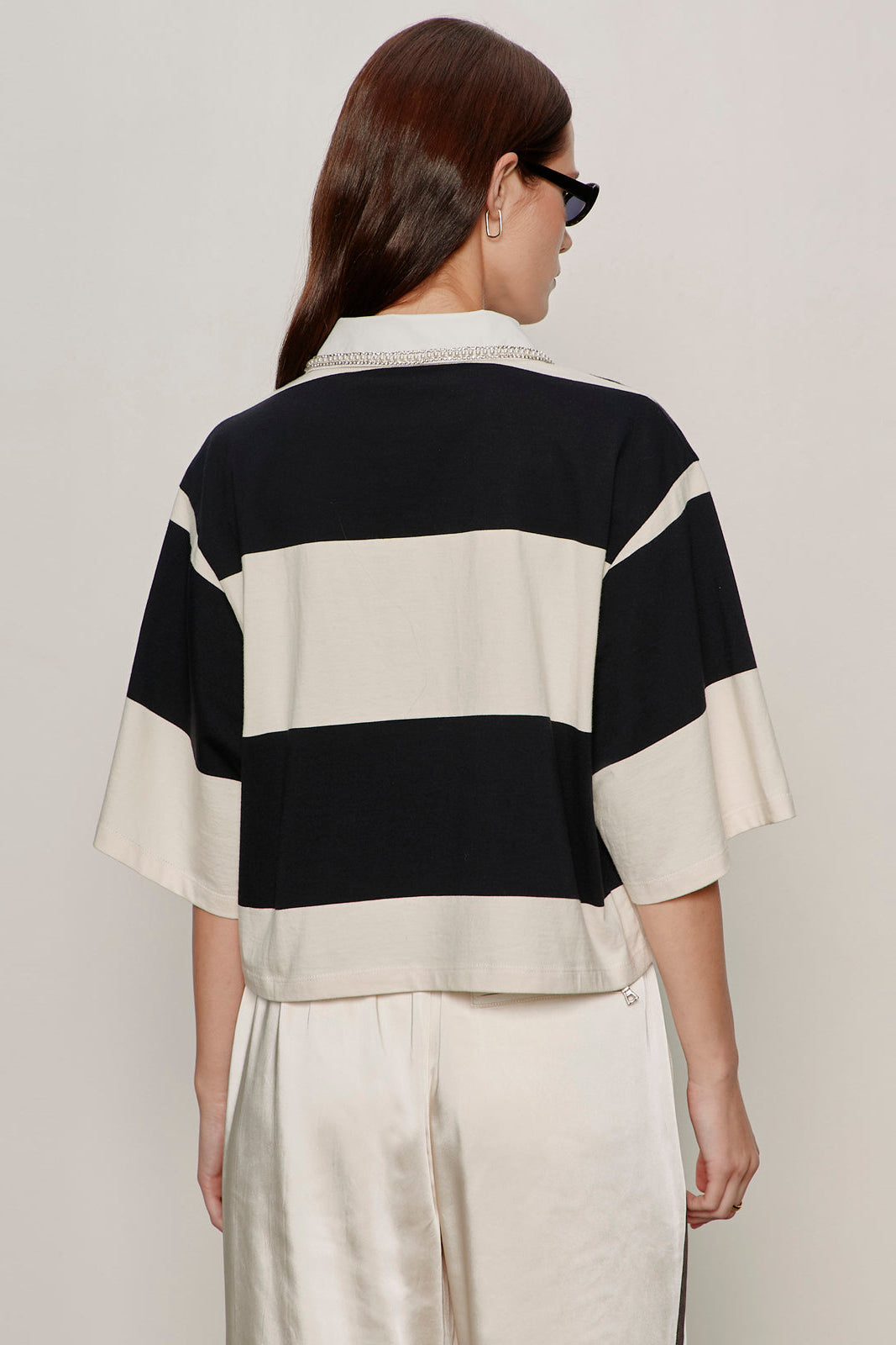 back view of black and white striped half sleeve polo with embellished collar