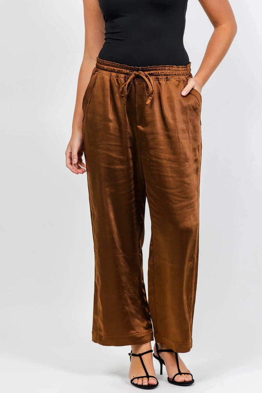 woman wearing brown satin draw string pants 