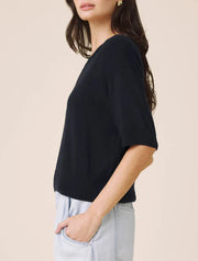 Woman wearing a navy short sleeved sweater