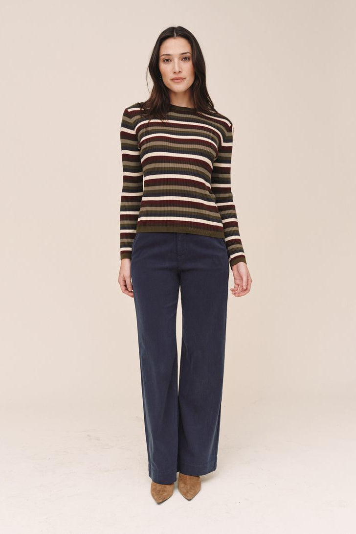 Woman wearing a striped sweater  on a beige background