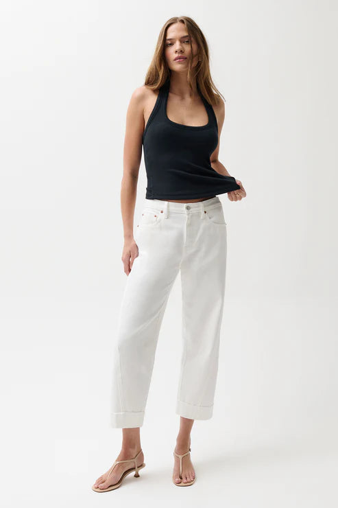 Woman wearing mid-rise white jeans with cuffed hem