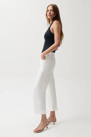 Woman wearing mid-rise white jeans with cuffed hem