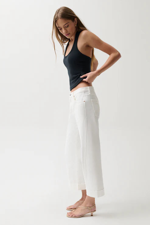Woman wearing mid-rise white jeans with cuffed hem