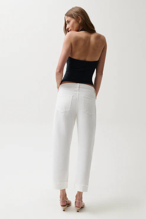 Woman wearing mid-rise white jeans with cuffed hem
