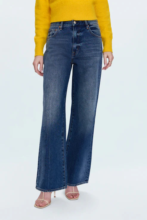 Person wearing blue jeans and a yellow sweater on a white background