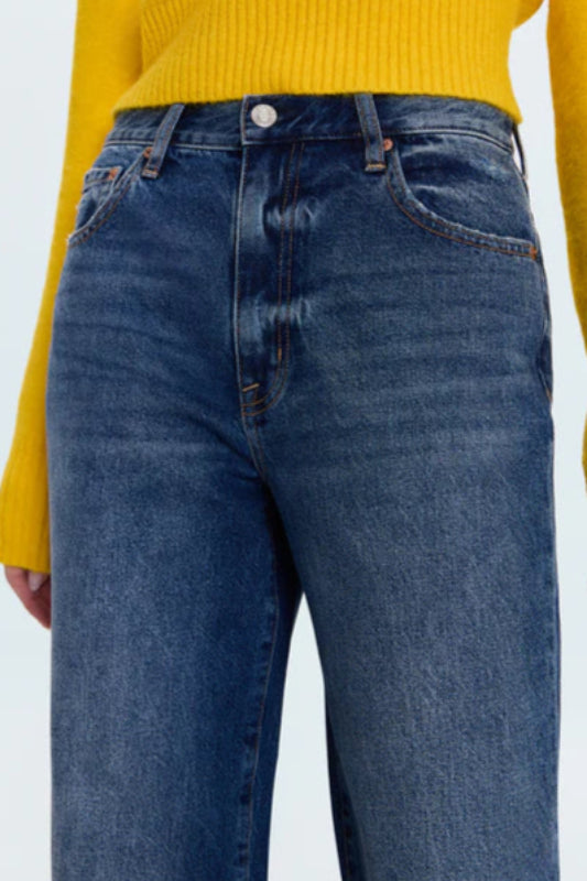 Person wearing a yellow sweater and blue jeans on a white background