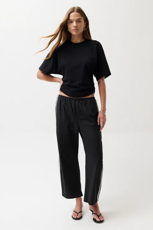 Woman wearing black pants with white stripes.