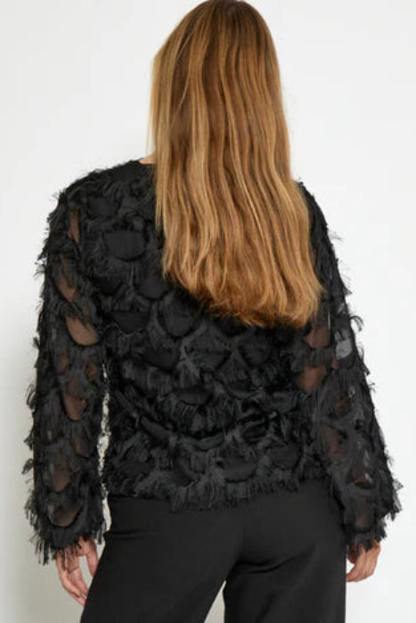 Person wearing a black lace top with sheer panels on a white background