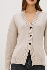 Close up of  a fitted 3 button beige knitted cardigan