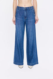 Blue jeans worn by a person on a white background