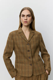 A woman modeling a brown plaid blazer with a double-breasted button closure and notch lapels. 