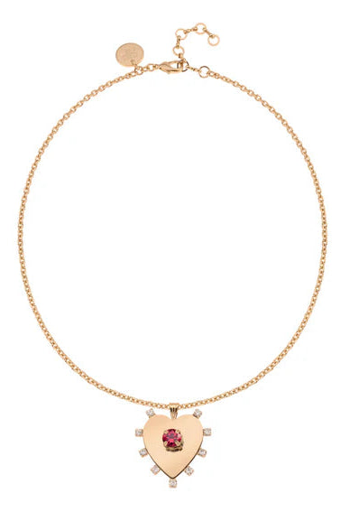 Gold necklace with a heart-shaped pendant featuring a red gemstone on a white background