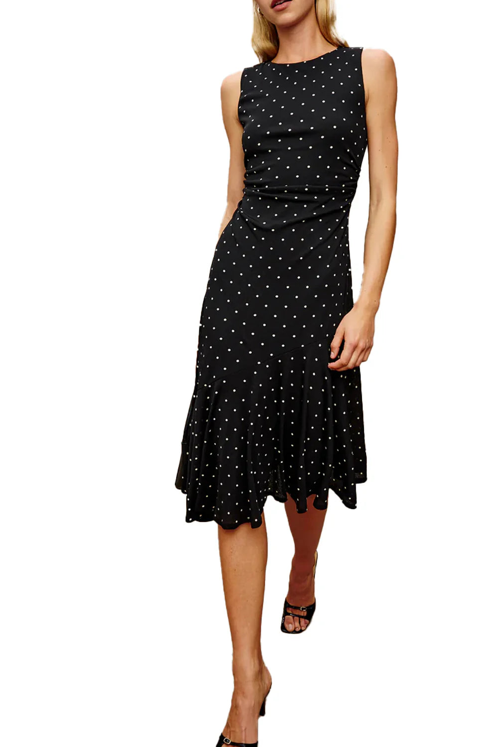 Woman wearing a black dress with white polka dots on a white background