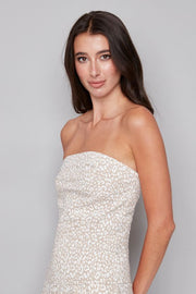Woman wearing a strapless white and beige leopard print top