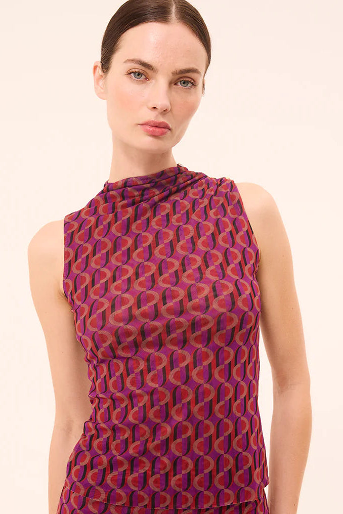 Woman wearing a sleeveless mesh top with a sixties inspired print
