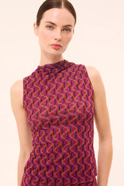 Woman wearing a sleeveless mesh top with a sixties inspired print