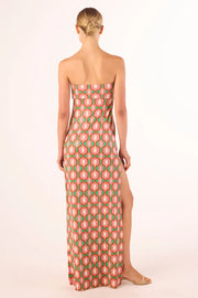 Woman wearing a strapless knit jersey dress with a pink and green geometric pattern 