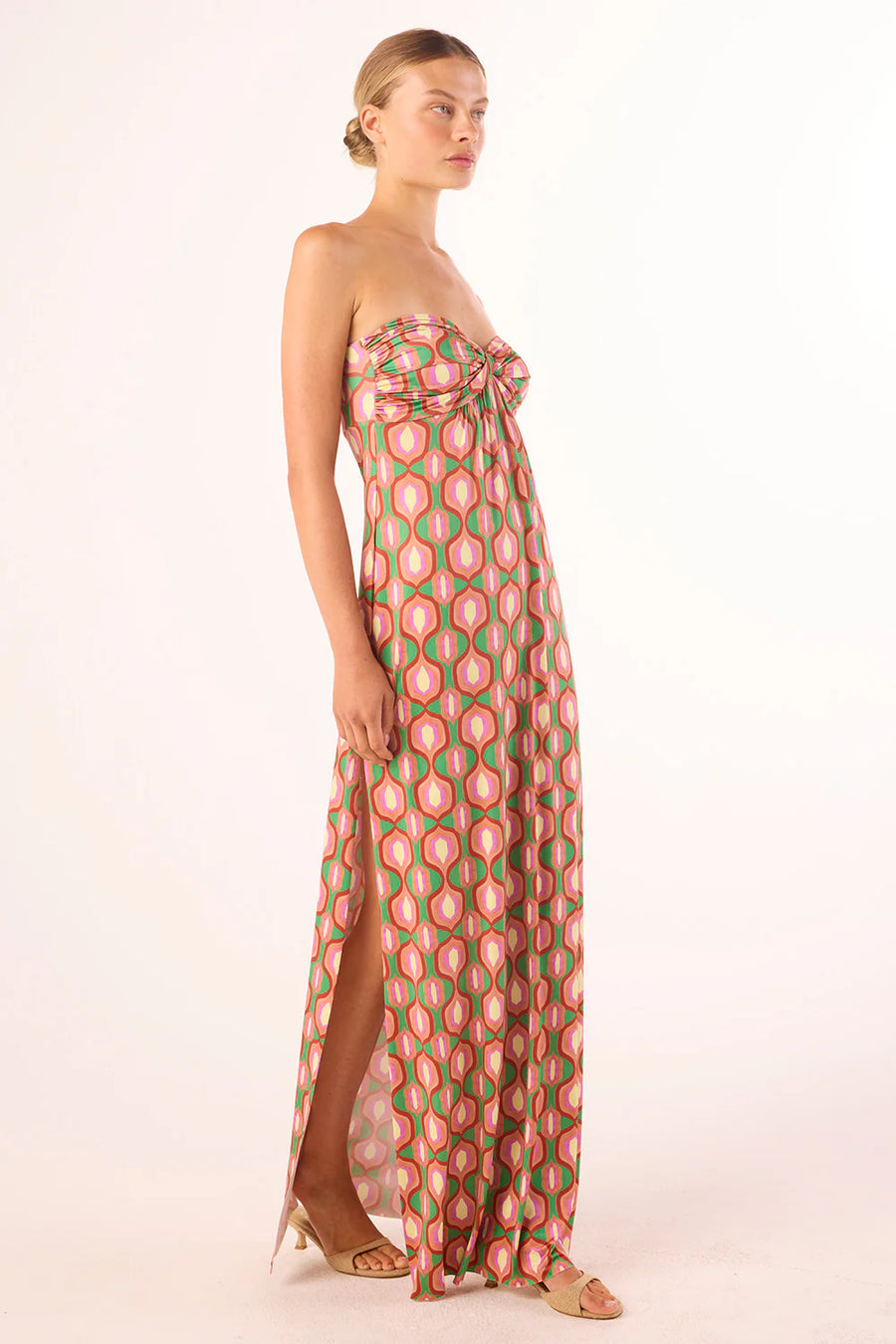 Woman wearing a strapless knit jersey dress with a pink and green geometric pattern 