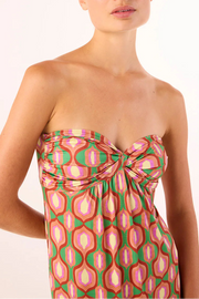 Woman wearing a strapless knit jersey dress with a pink and green geometric pattern 